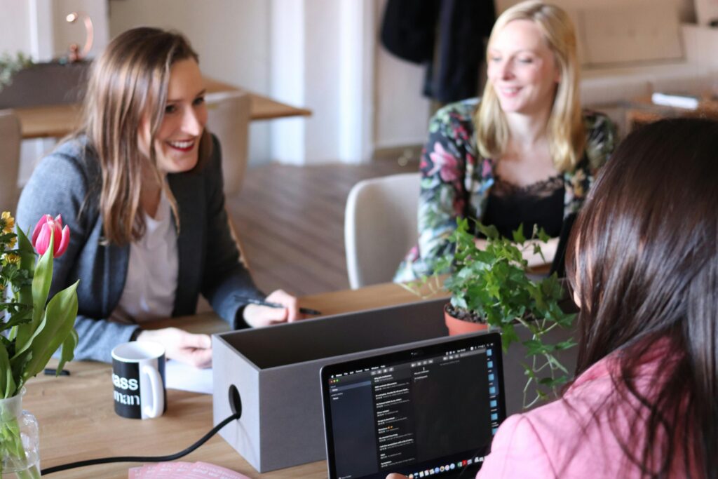 Frauen unterhalten sich im Büro. Drei Frauen unterhalten sich im Büro über ihre Arbeit.